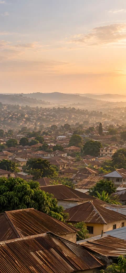 Illustrated brown rooftops across Ibadan in warm dawn light, shown in a phone-shaped frame