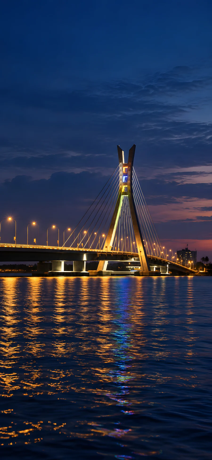 The forked pylon and cable fan of Lekki–Ikoyi Link Bridge above deep blue lagoon water.