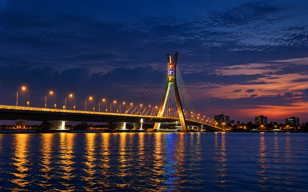 Lekki–Ikoyi, Blue Hour on an illustrative Mac screen. The forked pylon and cable fan of Lekki–Ikoyi Link Bridge above deep blue lagoon water.